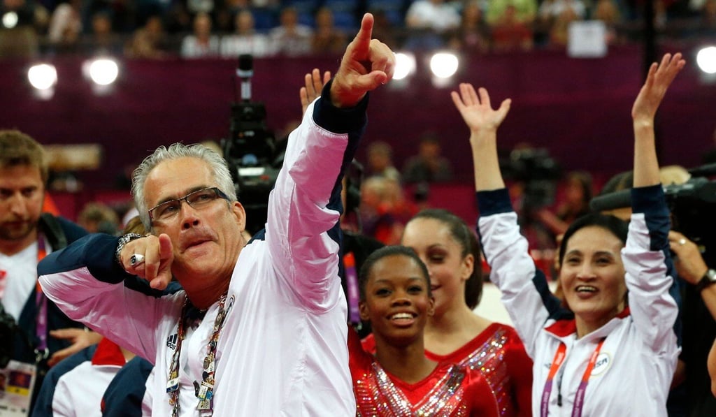US women gymnastics coach John Geddert celebrates with the team after the US won gold in the women's team artistic gymnastics event at the London Olympic Games in July 2012. Photo: AFP