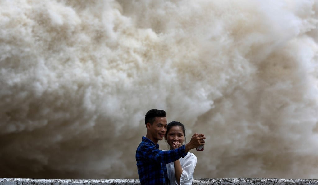 A couple takes a selfie at Hoa Binh hydroelectric power plant in Vietnam as the flood gates are opened after heavy rainfall caused by a typhoon. Photo: Reuters