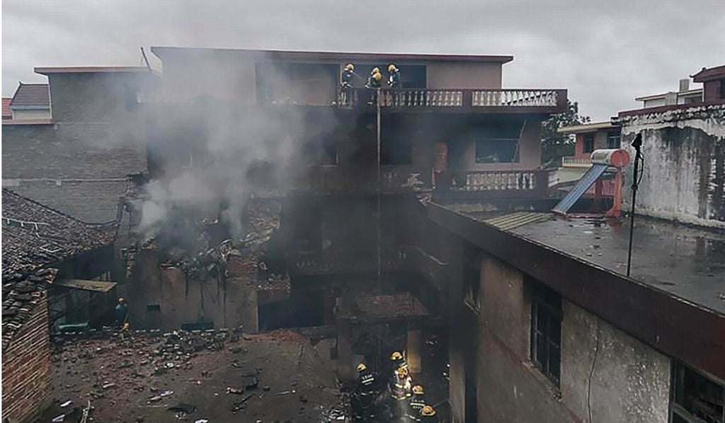 Smoke billows from one of the buildings damaged in the crash. Photo: CCTV