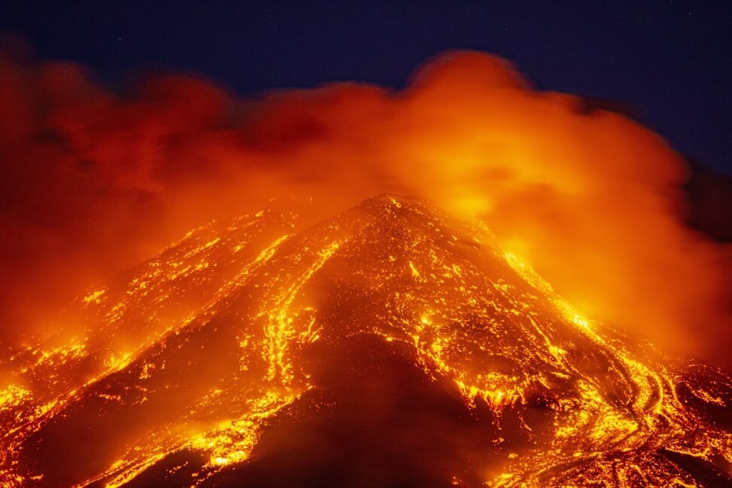Lava gushes from the Mount Etna volcano near Catania, southern Italy. The spectacular explosions were continuing on Sunday with the volcano in eastern Sicily spewing out towering clouds of ash and lava stones. Photo: AP Lava gushes from the Mount Etna volcano near Catania, southern Italy. The spectacular explosions were continuing on Sunday with the volcano in eastern Sicily spewing out towering clouds of ash and lava stones. Photo: AP