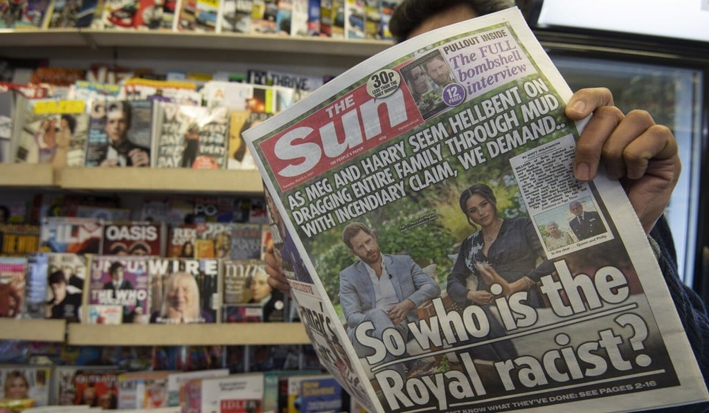 A man poses with a copy of the The Sun, with an article on the Oprah interview on the front page, at a newspaper stand in London on Tuesday. Photo: EPA-EFE