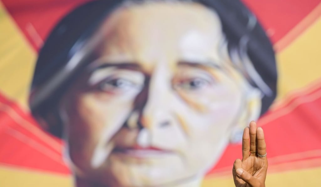 A demonstrator in Myanmar gives a three-finger salute – a symbol of the protests – in front of an image of Aung San Suu Kyi in Yangon, Myanmar. Photo: Reuters