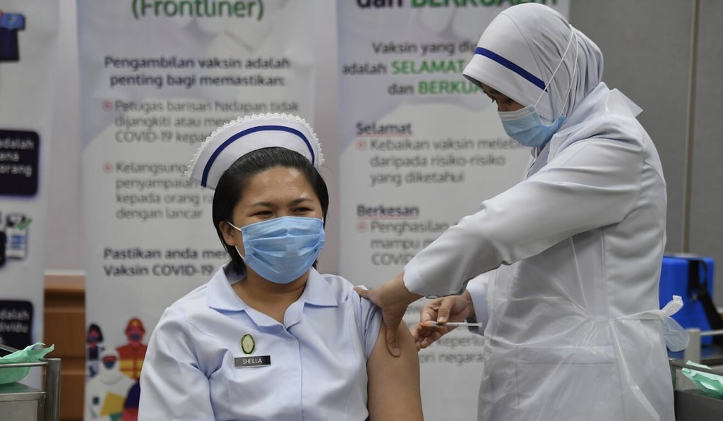 A medical worker receives her second dose of a Covid-19 vaccine at a health clinic in Malaysia. Photo: Bernama/DPA