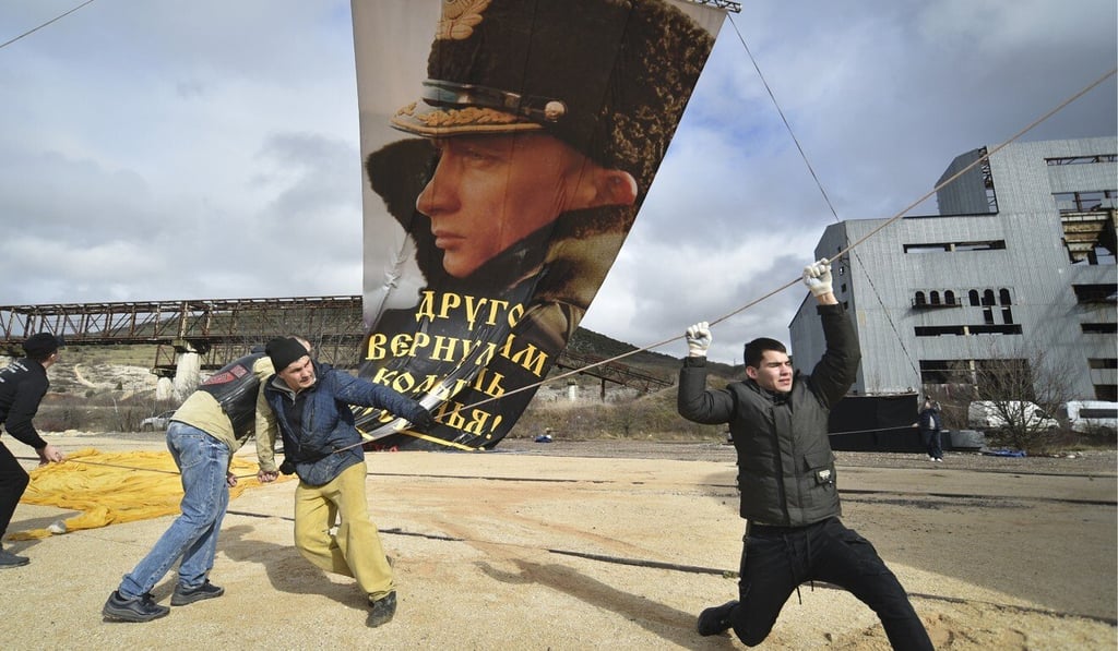 Enthusiasts fix a portrait of Russian President Vladimir Putin to a balloon to mark the anniversary of the 2014 annexation of Crimea in Sevastopol on Thursday. Photo: AP
