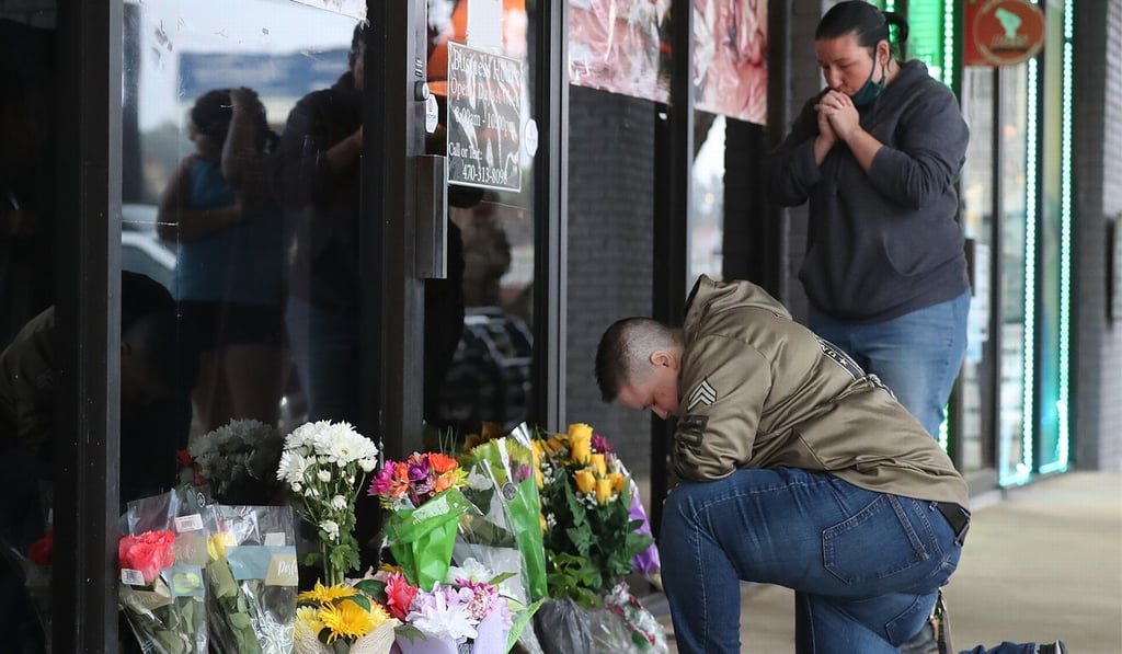 People pray after dropping off flowers at a massage parlour in Acworth, Atlanta. Photo: ZUMA Wire/dpa