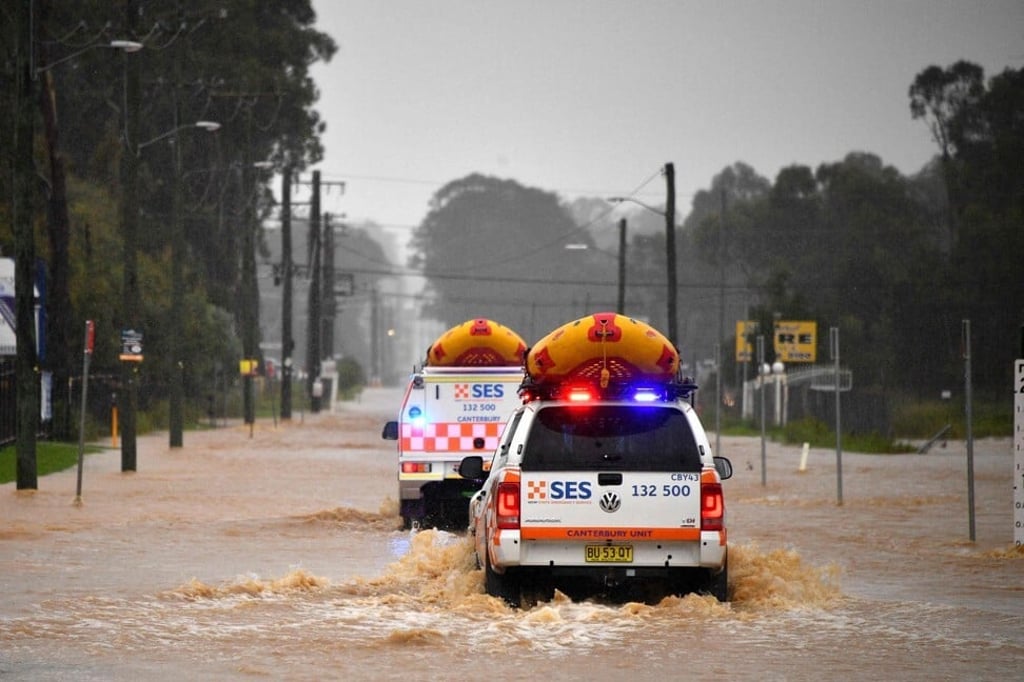 Emergency services vehicles approach flooded residential areas in western Sydney on Saturday. Photo: AFP