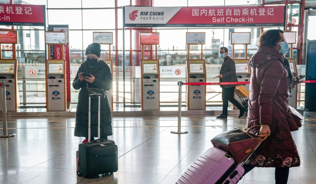 Travellers walk past Air China self check-in kiosks for domestic flights at Beijing Capital International Airport in February. A Chinese foreign ministry spokeswoman has clarified relaxed entry rules for foreigners inoculated with Sinovac jabs. Photo: Bloomberg
