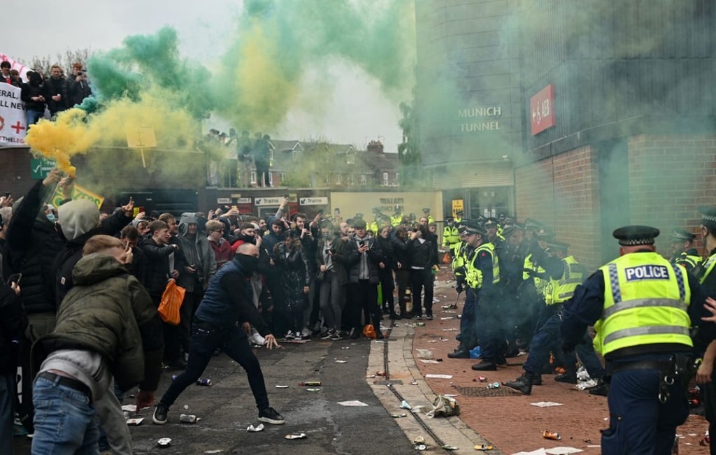 Police try to move football supporters away from Old Trafford stadium in Manchester, UK after a protest on Sunday. Photo: AFP