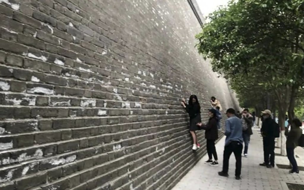 Tourists climbing and damaging the ancient city walls at Xian, centra China, despite requests they refrain from doing so. Photo: Handout