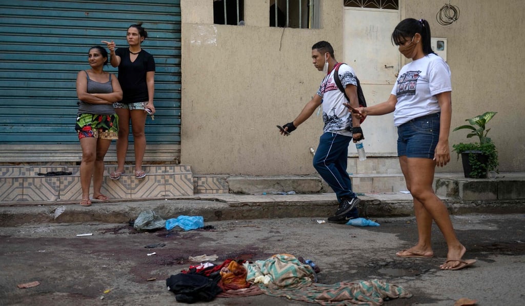 Jacarezinho residents take pictures of belongings covered in blood. Photo: AFP