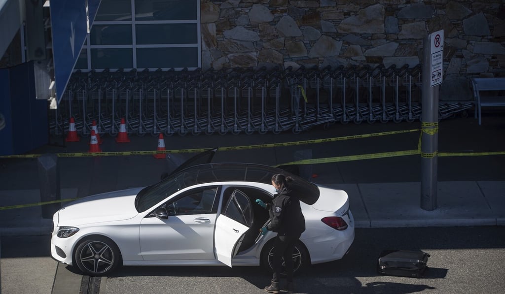 A Royal Canadian Mounted Police officer examining the inside of a car after the shooting. Photo: AP A Royal Canadian Mounted Police officer examining the inside of a car after the shooting. Photo: AP