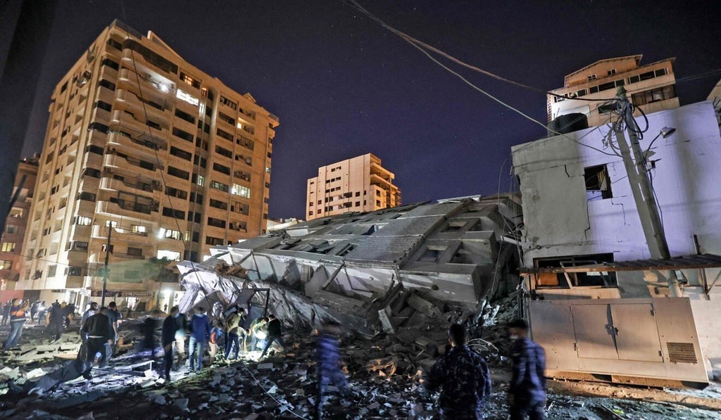 People gather at a collapsed building in the aftermath of Israeli air strikes on Gaza City on Tuesday. Photo: AFP