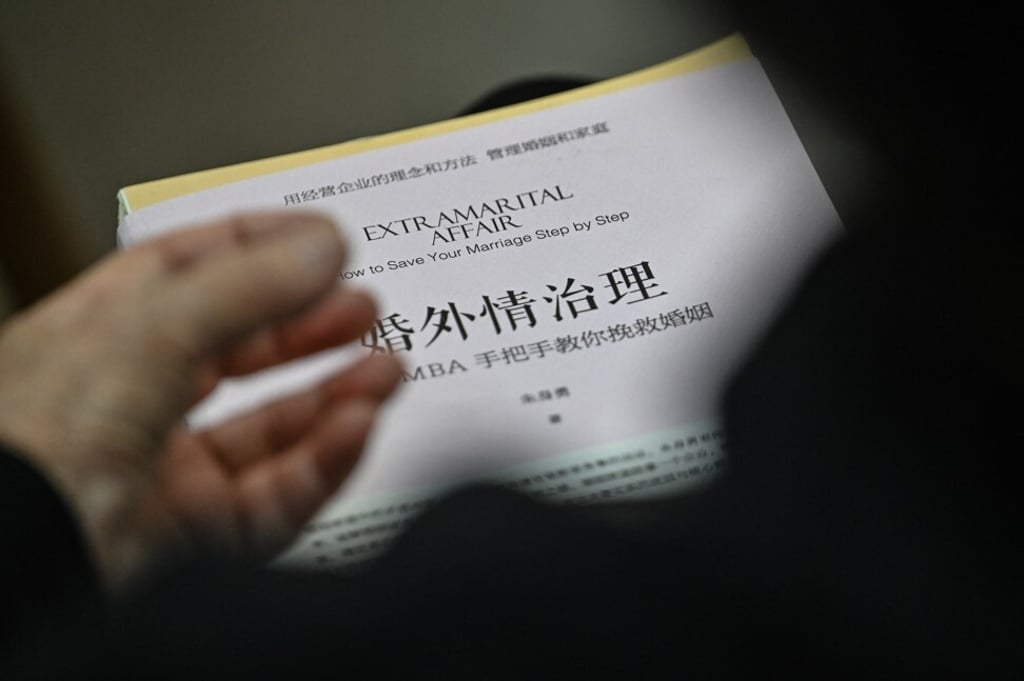 A woman holds a book about extramarital affairs as she listens to marriage counsellor during a session in Shanghai. Photo: AFP A woman holds a book about extramarital affairs as she listens to marriage counsellor during a session in Shanghai. Photo: AFP
