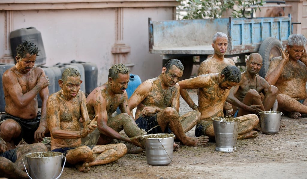 Visitors to a cow shelter in Ahmedabad apply cow dung to their bodies in the belief that it will boost their immunity to defend against Covid-19. Photo: Reuters Visitors to a cow shelter in Ahmedabad apply cow dung to their bodies in the belief that it will boost their immunity to defend against Covid-19. Photo: Reuters