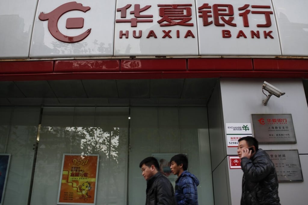 Locals walk past a Huaxia Bank in Shanghai. The lender has been fined twice in eight months for irregularities. Photo: Reuters Locals walk past a Huaxia Bank in Shanghai. The lender has been fined twice in eight months for irregularities. Photo: Reuters