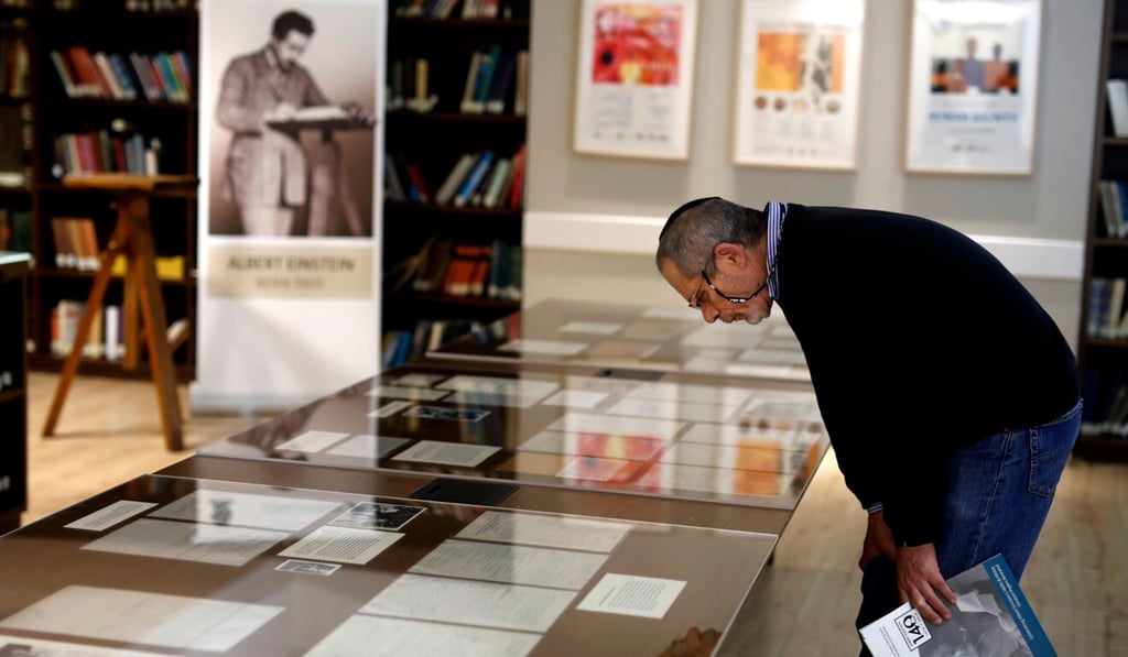 A man checks one of Albert Einstein's manuscripts on display in the Givat Ram Hebrew University of Jerusalem in March 2019. Photo: AFP