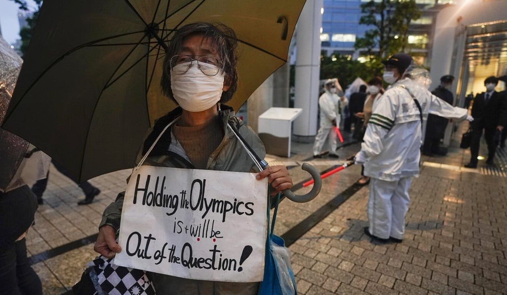 A protester against Tokyo 2020 Olympic Games appeals to commuters leaving offices at the Tokyo 2020 organising committee offices as a three-day meeting of the IOC Coordination Commission for the Games of the XXXII Olympiad concludes. Photo: EPA