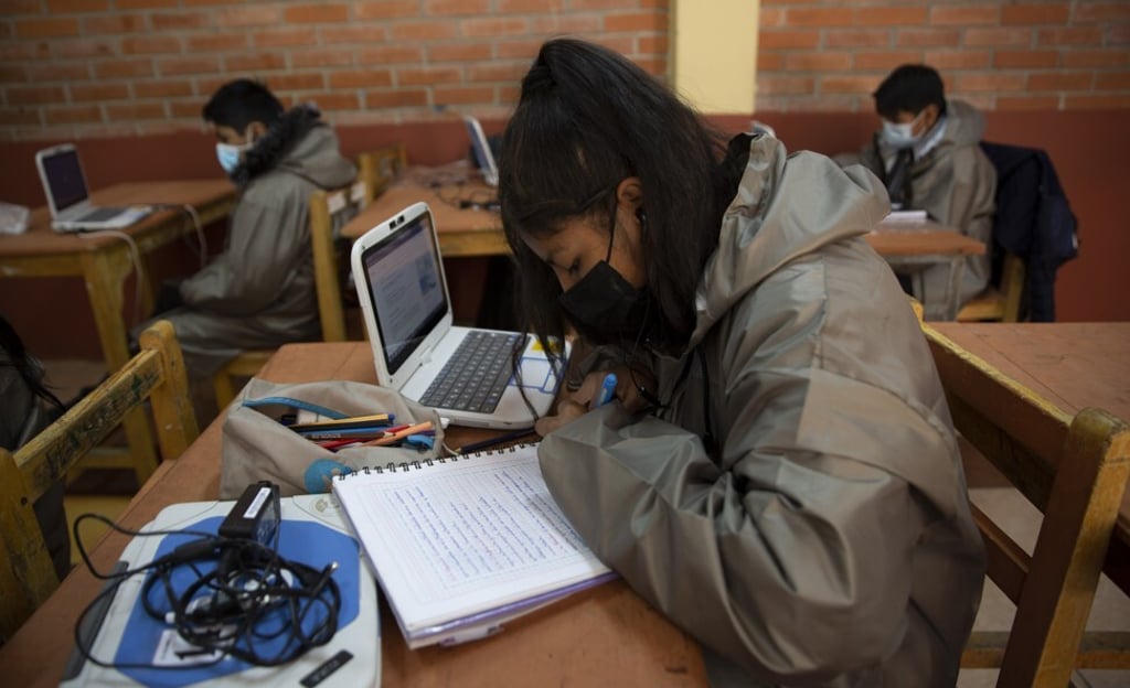 Students wearing masks to curb the spread of the coronavirus take online classes with computers loaned to them by the teachers of the Gualberto Villarroel school in La Paz, Bolivia, on May 12. The school’s teachers and some parents are providing the devices to students who do not have access to a computer or cellphone to attend classes online. The school itself provides the internet signal. Photo: AP
