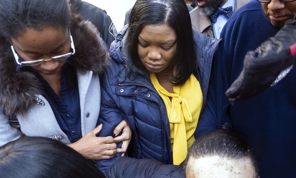 Former prison guard Tova Noel, centre in yellow blouse, leaves federal court in New York on Friday. Photo: AP