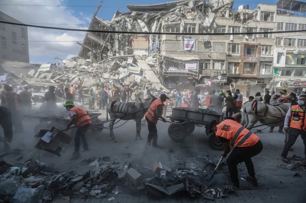 Palestinian volunteers clean up streets that were hit by Israeli air strikes in Gaza. Photo: DPA via Zuma Press/TNS Palestinian volunteers clean up streets that were hit by Israeli air strikes in Gaza. Photo: DPA via Zuma Press/TNS