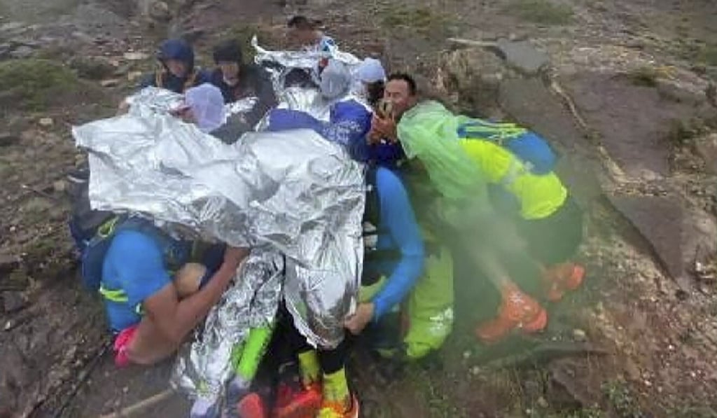 Runners huddle for warmth as unexpected extreme weather wreaks havoc during the race. Photo: Handout