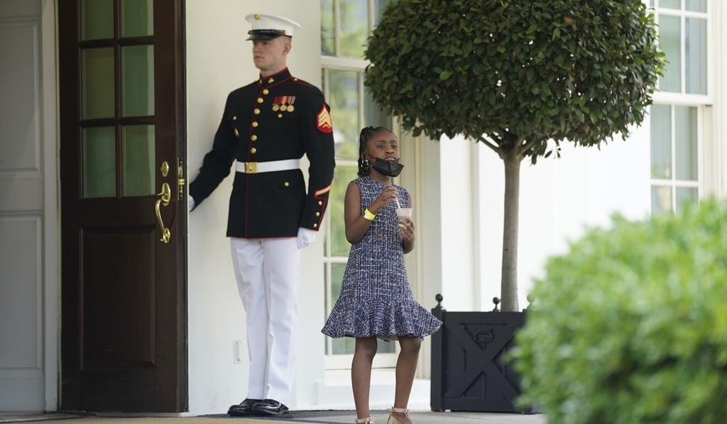 A US Marine holds the West Wing door open as Gianna Floyd, the daughter of George Floyd, walks out of the White House on Tuesday. Photo: AP
