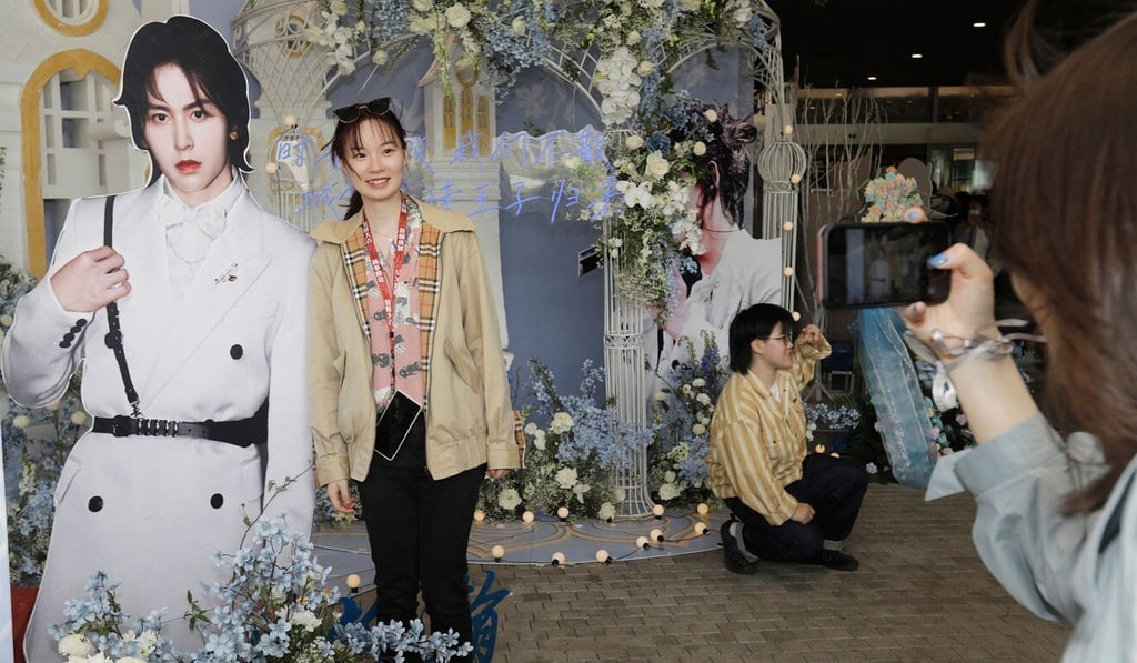 A fan of Chinese Word of Honor poses for a picture next to a life-size cut-out of one of its stars. Photo: AFP A fan of Chinese Word of Honor poses for a picture next to a life-size cut-out of one of its stars. Photo: AFP