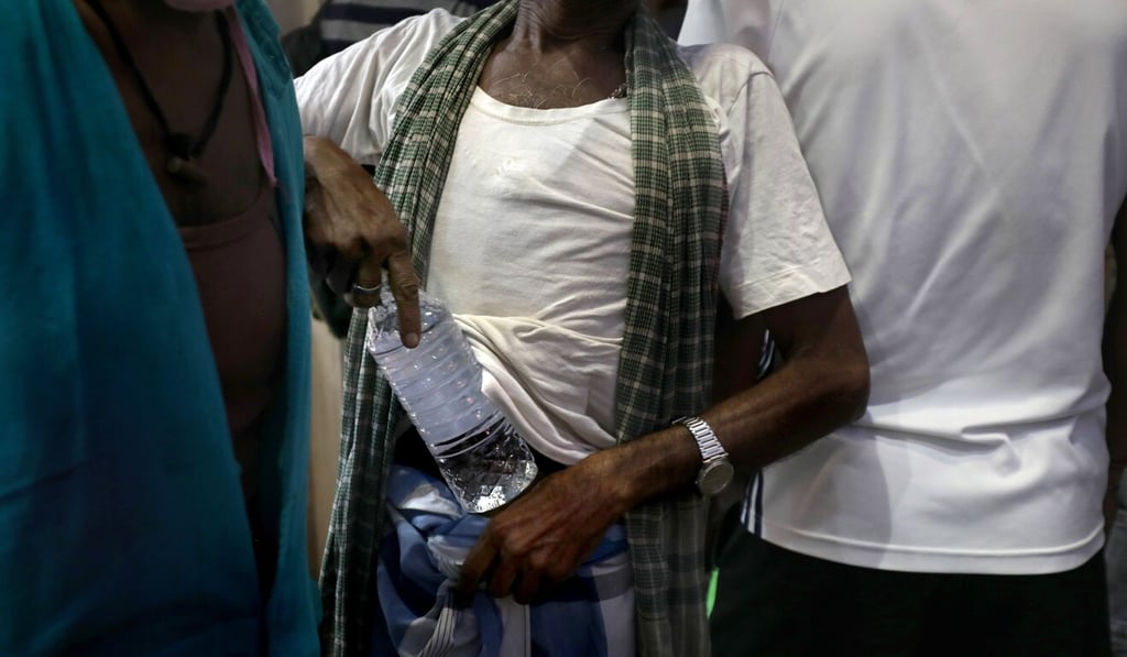 A customer carries a bottle of alcohol bought from a liquor shop in India earlier this month. Photo: EPA