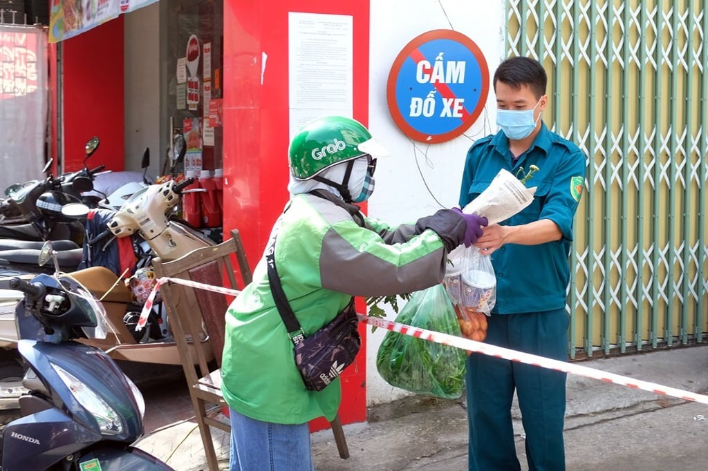 A rider delivers food to a man inside a quarantine area in Hanoi on May 26, 2021. Photo: EPA-EFE