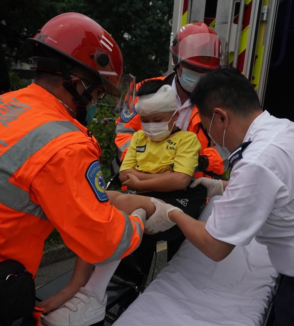 Emergency personnel help one of the children injured in the crash. Photo: Felix Wong