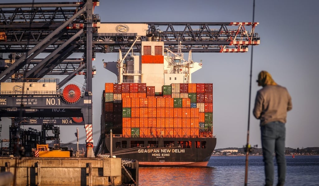 A man stands in front of a container ship at Port Botany in Sydney on May 31. A survey of institutional investors found that warehouses in Sydney and Melbourne were the top two city-sector investment combinations favoured by respondents. Photo: Bloomberg