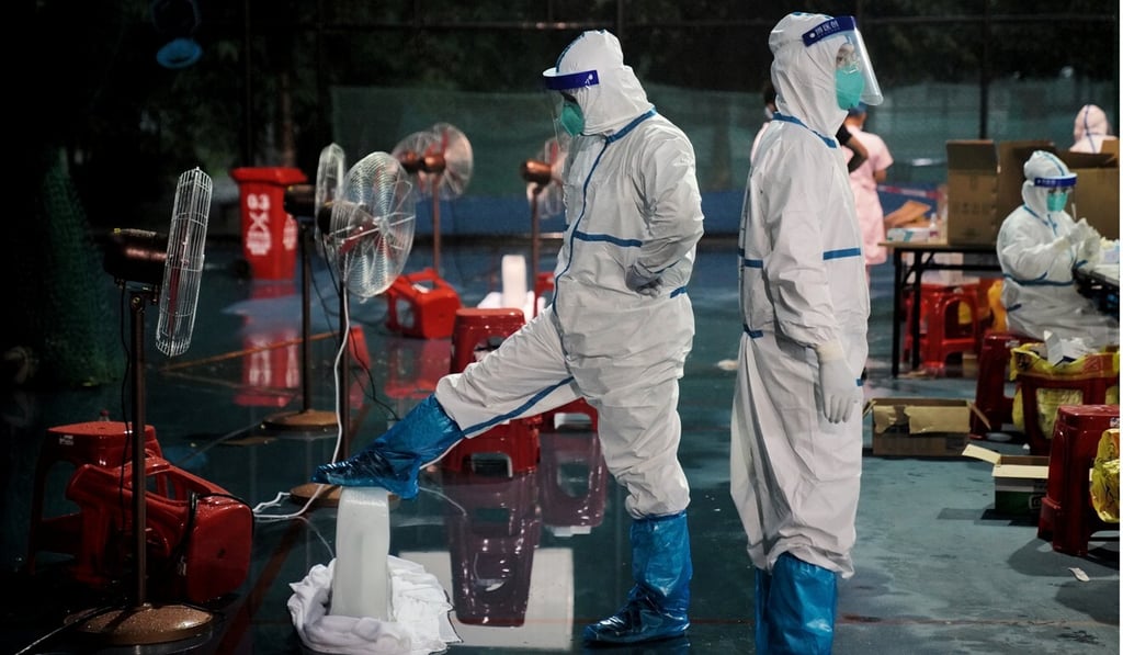 Medical workers use ice blocks and fans to cool off at a makeshift Covid-19 testing site in Guangzhou. Photo: Reuters