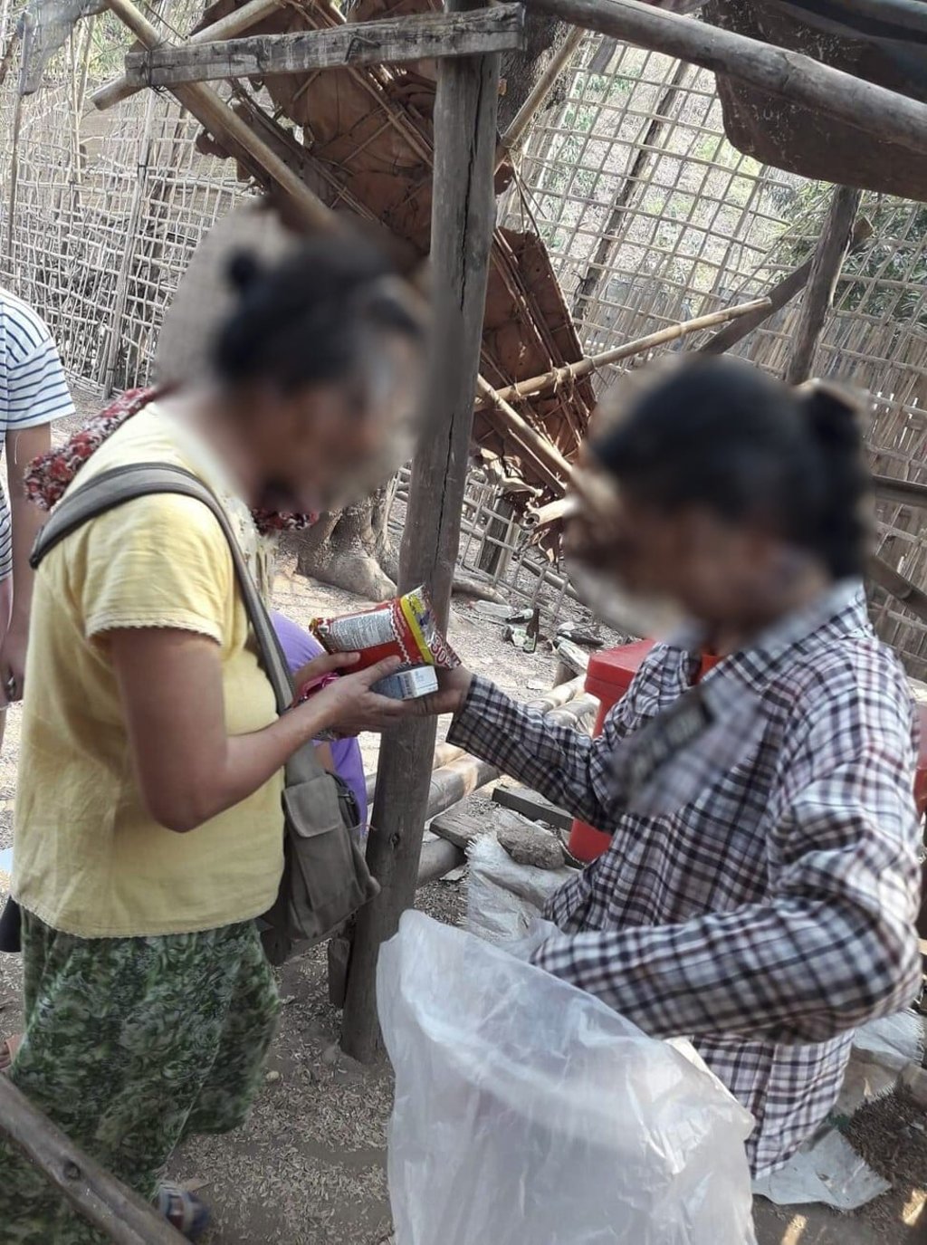 Naw Say Say’s mother (left) receives food from her neighbours in the Mae La refugee camp in Thailand. Photo: courtesy of Connecting Myanmar