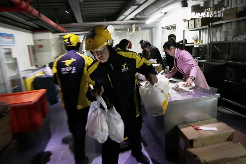 Couriers from Meituan, operator of China’s largest local services e-commerce platform, are seen handling food orders for delivery from a centre in Beijing. Photo: AP