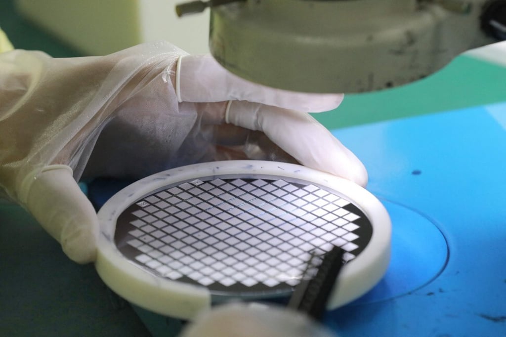 An employee of Jiejie Semiconductor Co in Nantong, in eastern China's Jiangsu province, handles a silicon wafer. Photo: Agence France-Presse