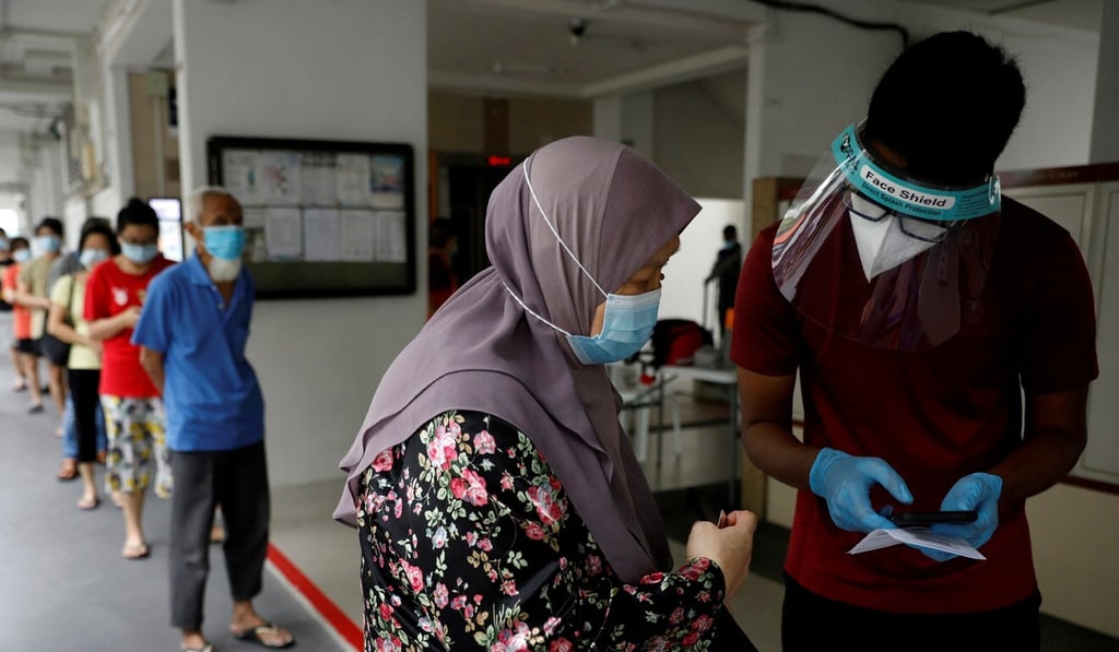 Residents of a public housing estate queue for mandatory Covid-19 swab tests in Singapore. Photo: Reuters