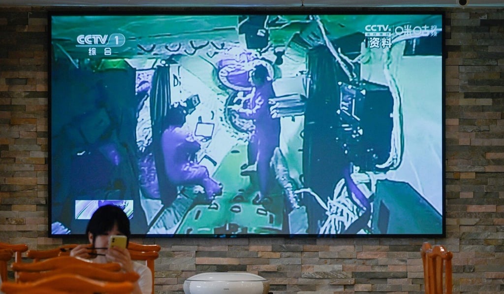 A television broadcasts Chinese astronauts in the Tiangong station, at a restaurant in Beijing on June 18. Photo: AFP