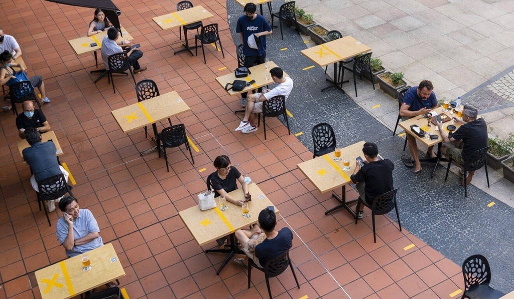Customers sit at socially distanced tables outside a restaurant in Singapore. Photo: Bloomberg