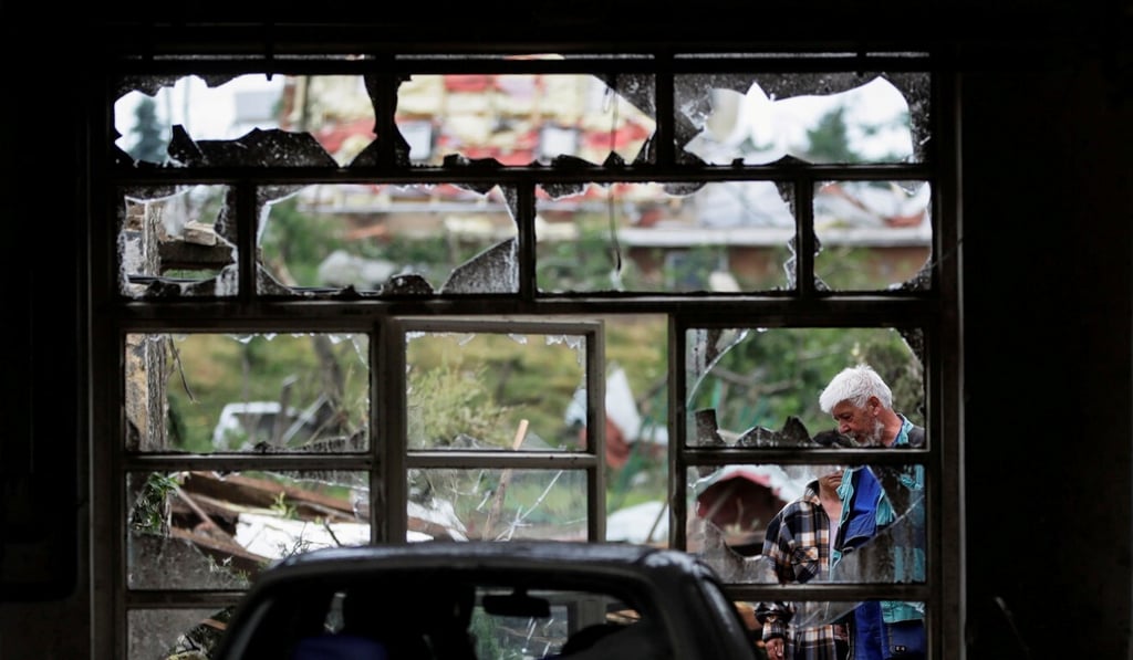 People are seen through a damaged window in the aftermath of the tornado in Mikulcice village, Czech Republic. Photo: Reuters People are seen through a damaged window in the aftermath of the tornado in Mikulcice village, Czech Republic. Photo: Reuters