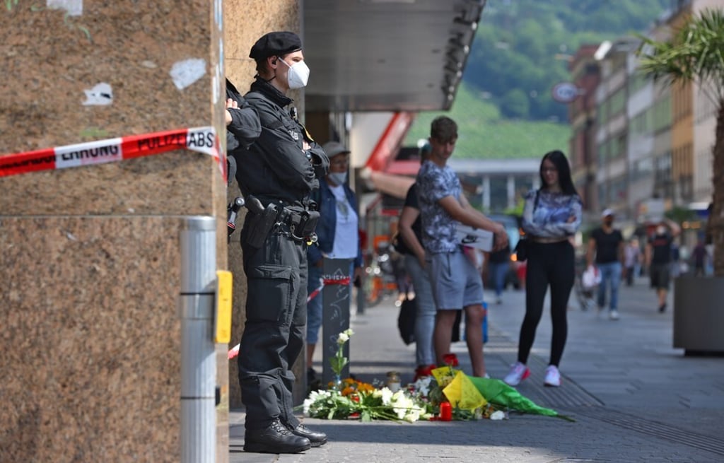 A police officer stands next to a department store in downtown Wuerzburg, Germany, where a fatal knife attack took place on Friday. Photo: DPA