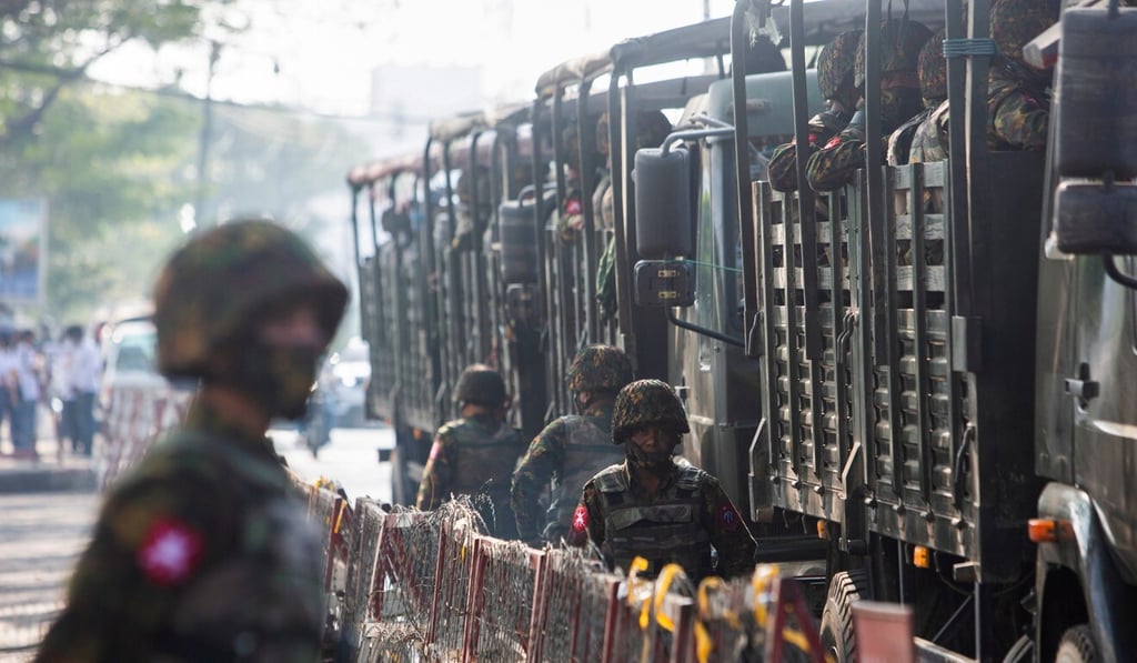 Soldiers stand next to military vehicles as people gather to protest against the military coup in Yangon. Photo: Reuters