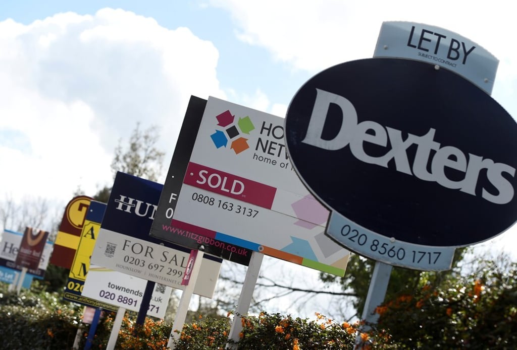 Property signs are seen attached to railings in a housing estate in London. Photo: Reuters