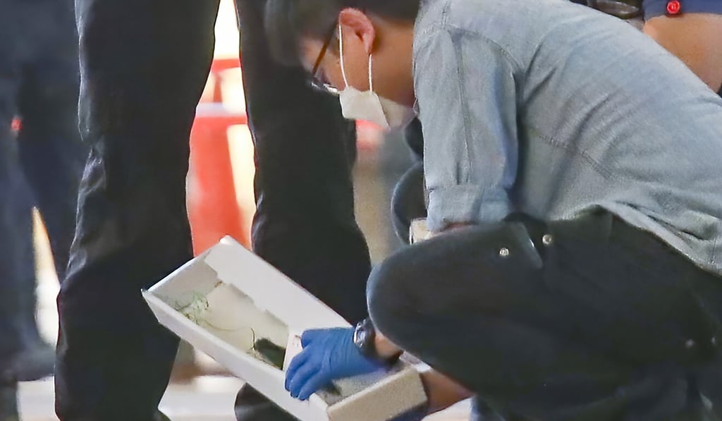 Police gather evidence at the crime scene outside Sogo in Causeway Bay. Photo: Xiaomei Chen