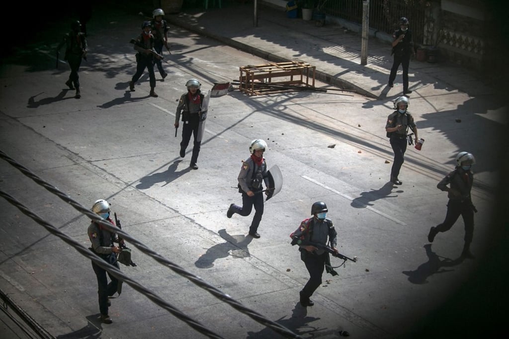 Police running towards protesters to disperse a demonstration being held against the military coup in Yangon in March 2021. Photo: AFP