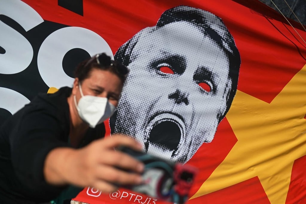 A woman takes a selfie in front of a sign with a photo depicting Brazilian President Jair Bolsonaro in Rio de Janeiro, Brazil on Saturday. Photo: AFP A woman takes a selfie in front of a sign with a photo depicting Brazilian President Jair Bolsonaro in Rio de Janeiro, Brazil on Saturday. Photo: AFP