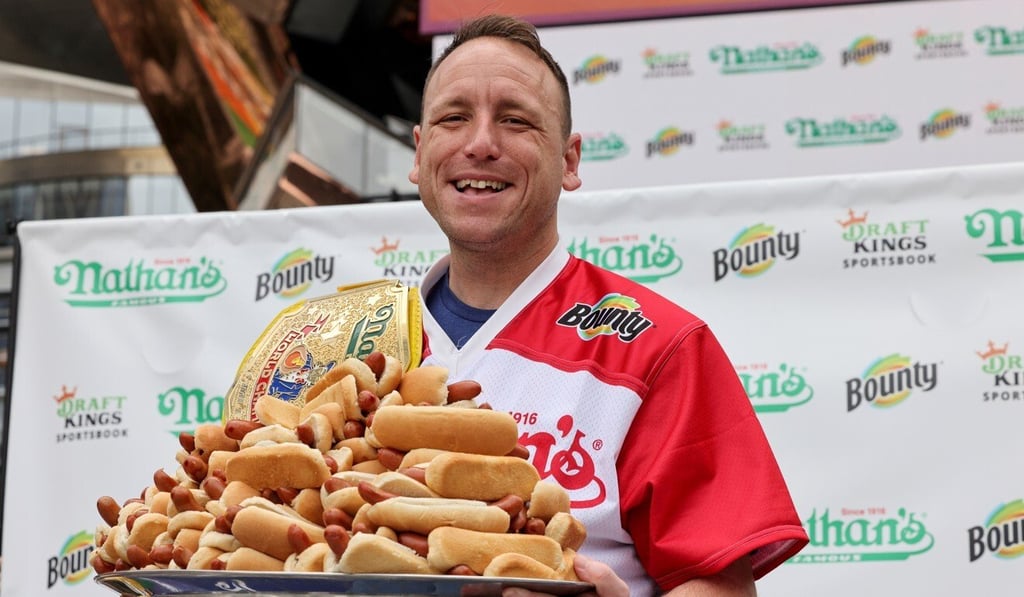 Joey Chestnut holds a tray of hot dogs. Photo: Reuters