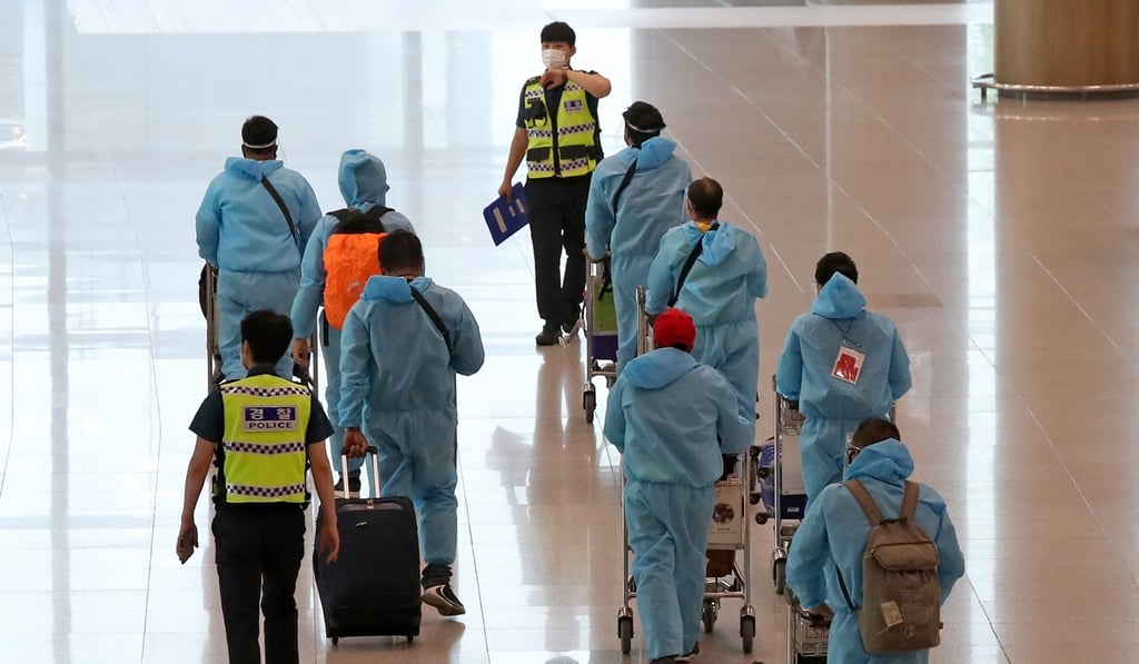 Travellers from India – a high-risk country – are guided by police upon arrival at South Korea’s Incheon International Airport on Friday. Photo: Yonhap/EPA