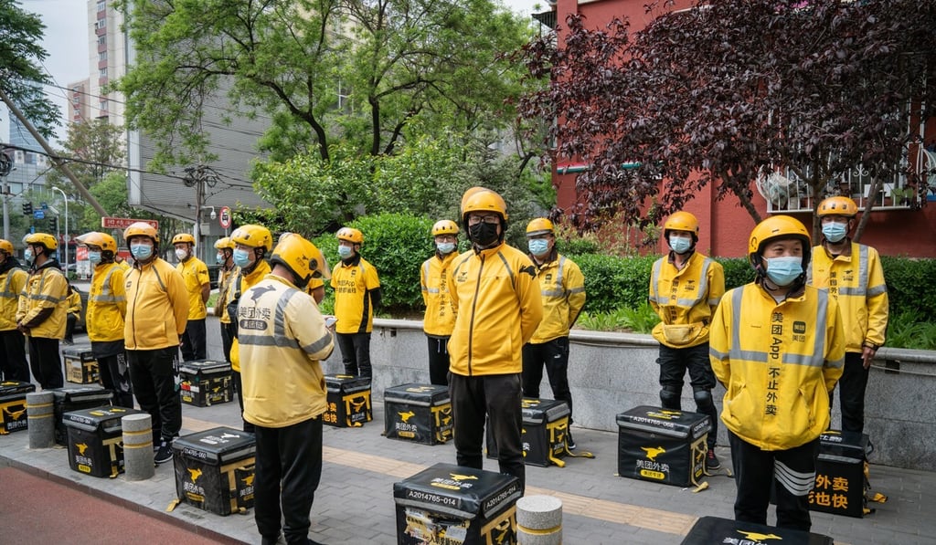 Food delivery couriers for Meituan stand with insulated bags during a morning briefing in Beijing. In recent times, the company has been among tech mammoths who have been reined in. Photo: Bloomberg