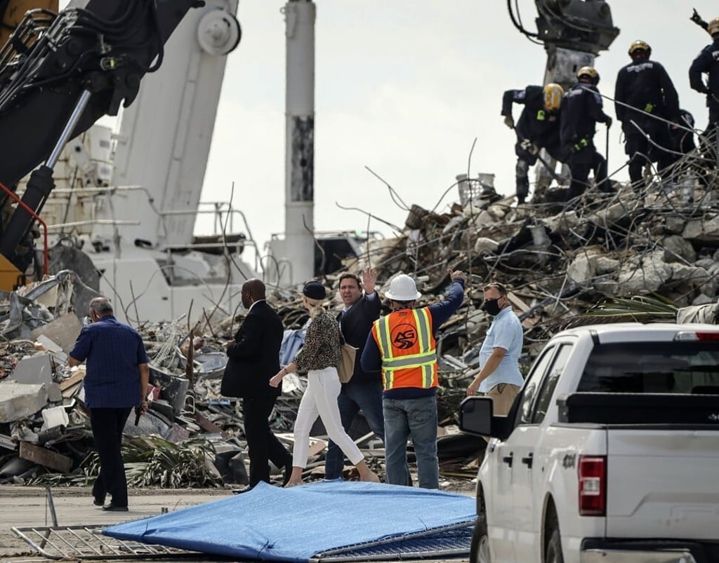 Florida Governor Ron DeSantis, centre, surveys the site of the rubble on July 5, 2021. Photo: Miami Herald via AP