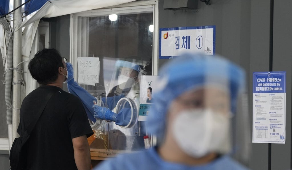 A medical worker takes a swab sample from a member of the public at a Covid-19 testing station in Seoul on Thursday. Photo: EPA
